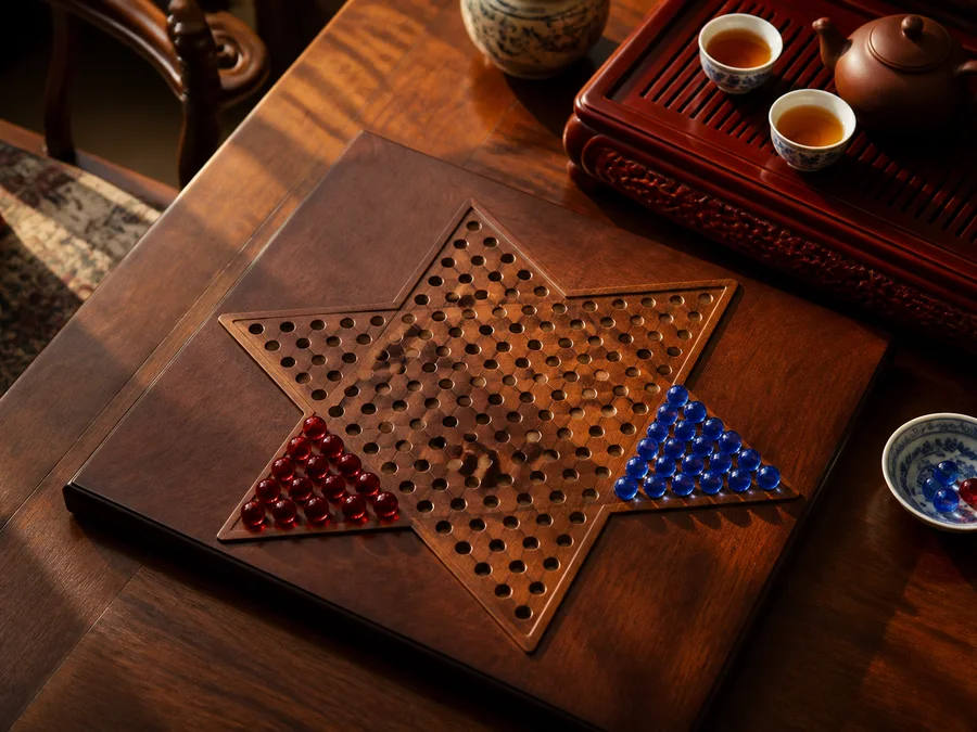 A star-shaped Chinese Checkers board with red and blue marbles in opposite camps